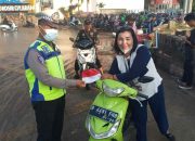 Polisi membagikan bendera merah putih kepada pengendara sepeda motor.